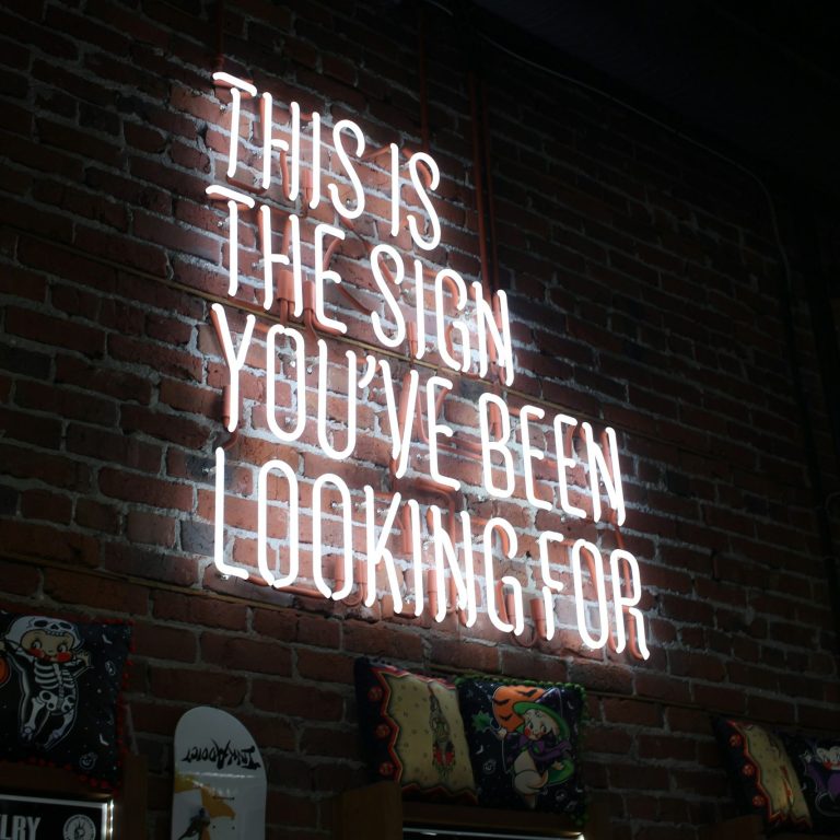 Neon-Schild an einer Backsteinwand: "Dies ist das Zeichen, nach dem Sie gesucht haben."